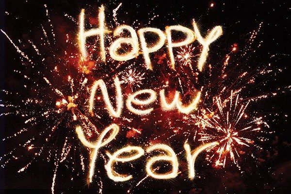 A spectacular display of fireworks lighting up the night sky, with the words 'Happy New Year' in fiery text, marking the start of a joyous celebration
